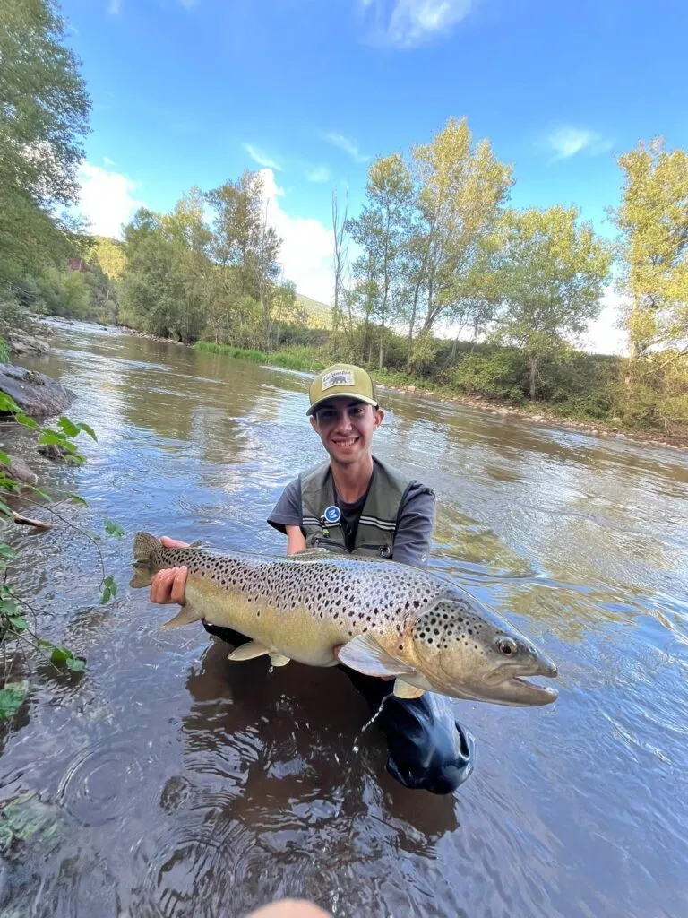 Pescador amb truita al riu
